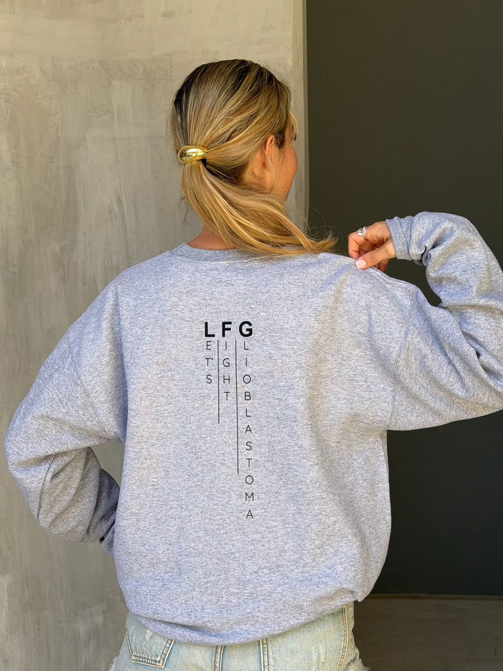 Person wearing a gray sweatshirt with 'LFG' text on the back, standing against a plain wall.