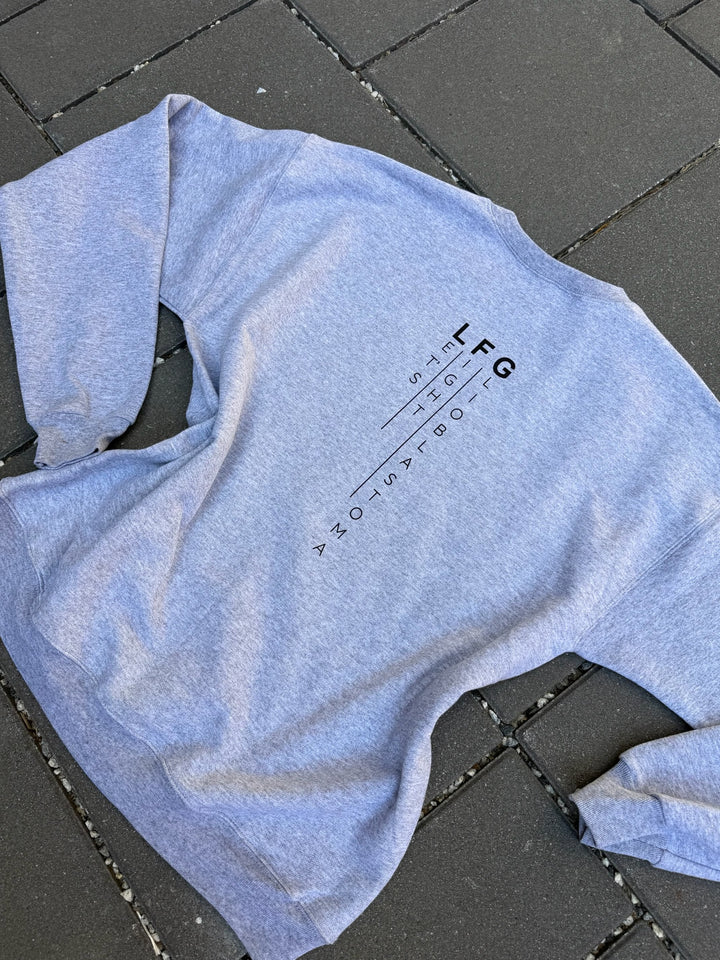 Gray sweatshirt with Let's Fight Glioblastoma text on a textured surface