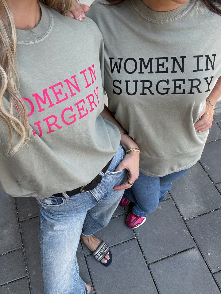 Two people wearing gray t-shirts with 'WOMEN IN SURGERY' text in pink and black.