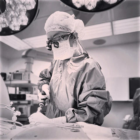 Dr. Betsy Grunch (Ladyspinedoc) in surgical attire, operating in an operating room.