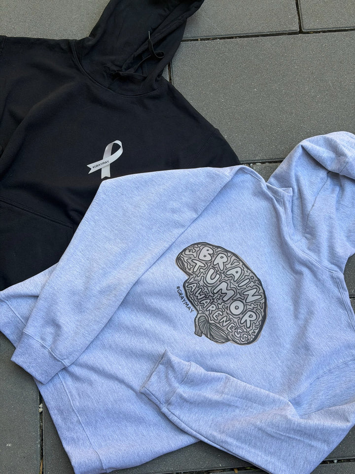 Black and gray hoodies with brain designs on a gray surface. 