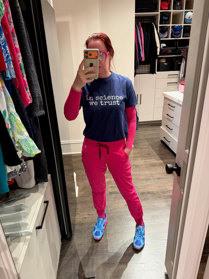 person standing in closet wearing a navy shirt with the phrase "in science we trust" 