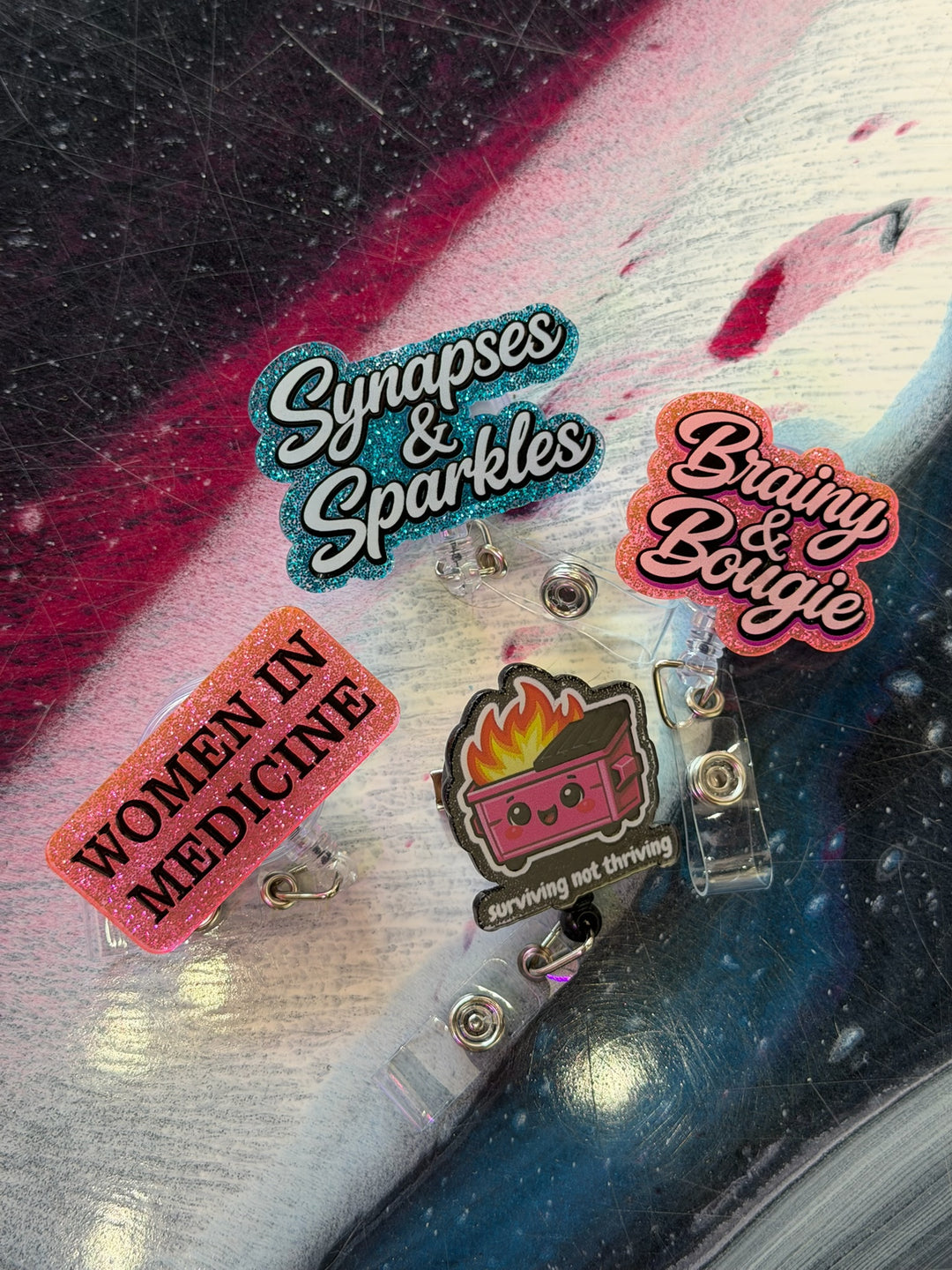 Set of colorful ladyspinedoc badge reels with text on a textured surface