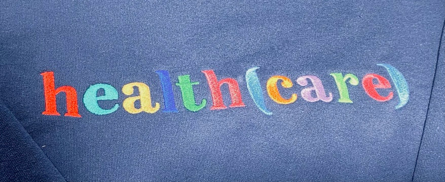 Colorful text 'health (care)' on a blue sweatshirt