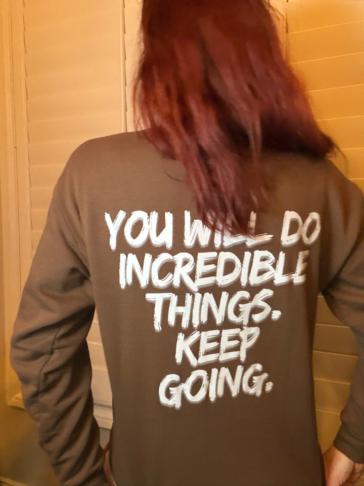 Ladyspinedoc wearing a brown-colored sweatshirt with motivational You Will Do Incredible Things. Keep Going. 