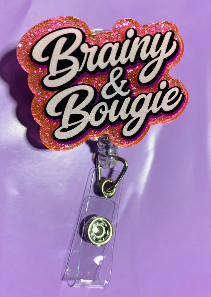 Badge holder with 'Brainy & Bougie' text on a pink glitter background