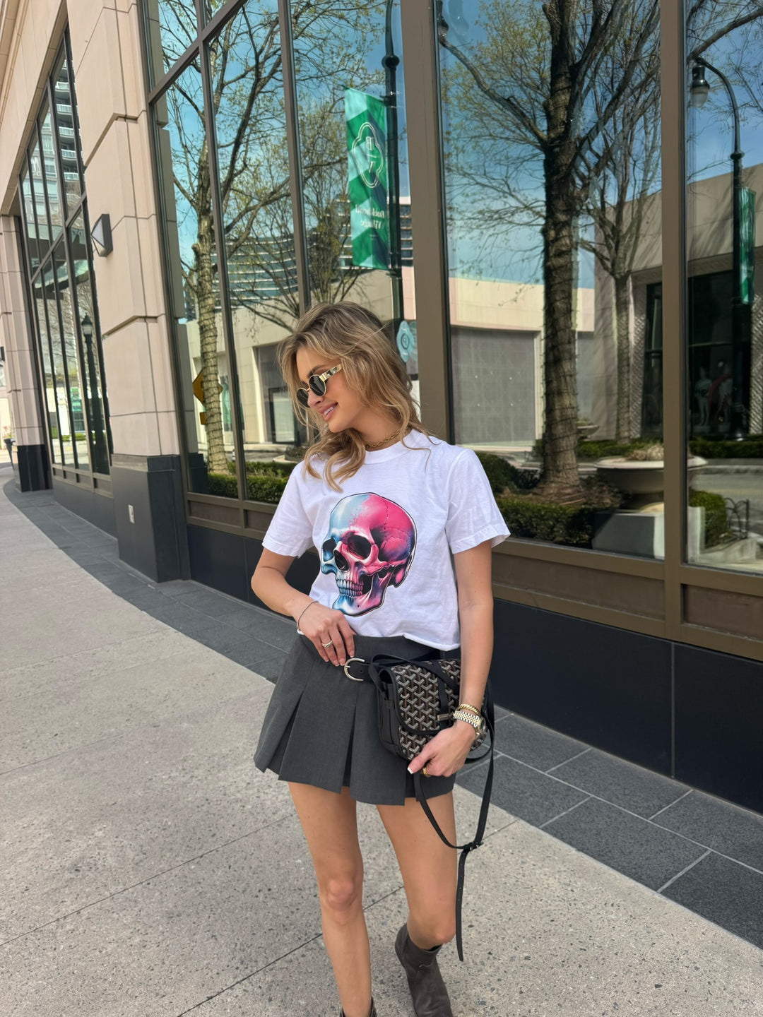 Smiling model in cityscape wearing Skull Style Cropped Tee – White Short Sleeve Crop Top with Skull Design