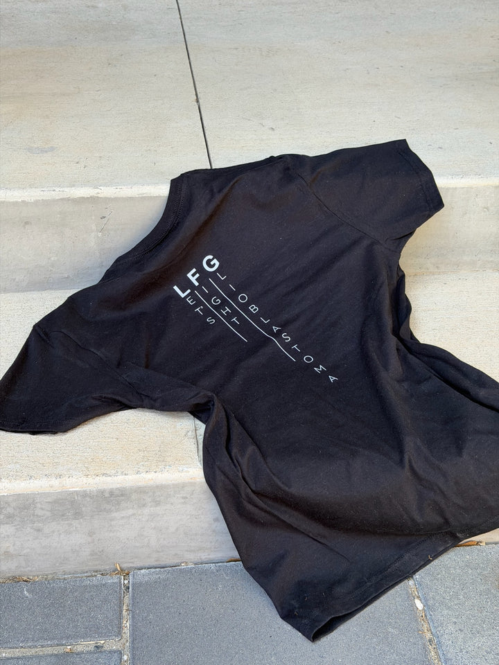 Black t-shirt with Let's Fight Glioblastoma text on a stone surface