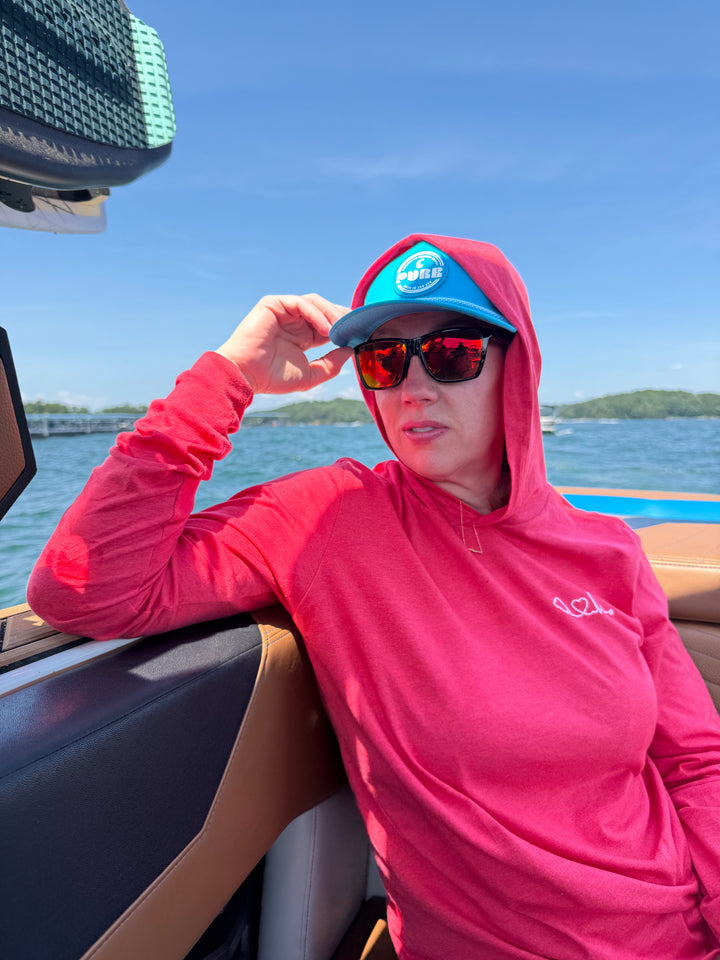 Ladyspinedoc wearing Heart of Medicine red hoodie while riding in a boat.