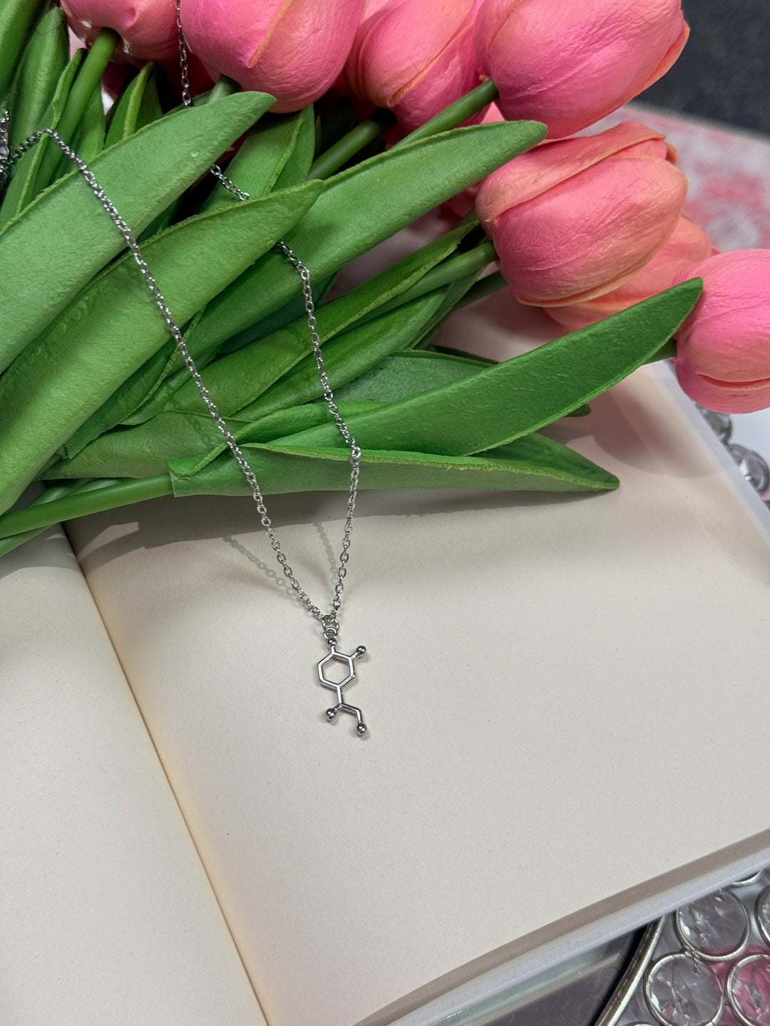 molecule necklace draped over tulips