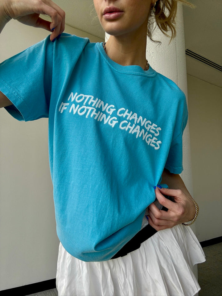 Model wearing the “Nothing Changes If Nothing Changes” Tee Shirt in Blue