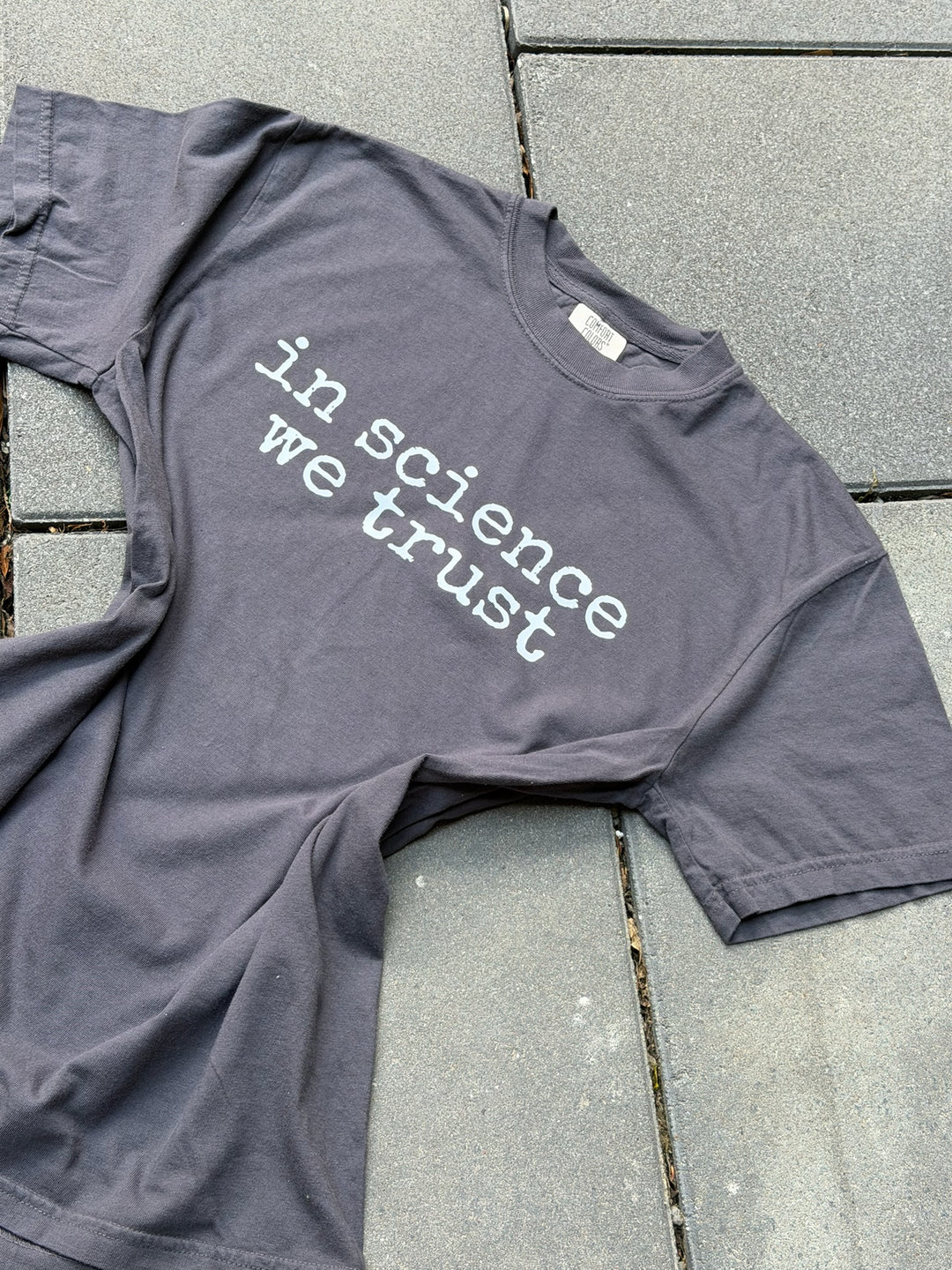 gray shirt with the phrase in science we trust in white font