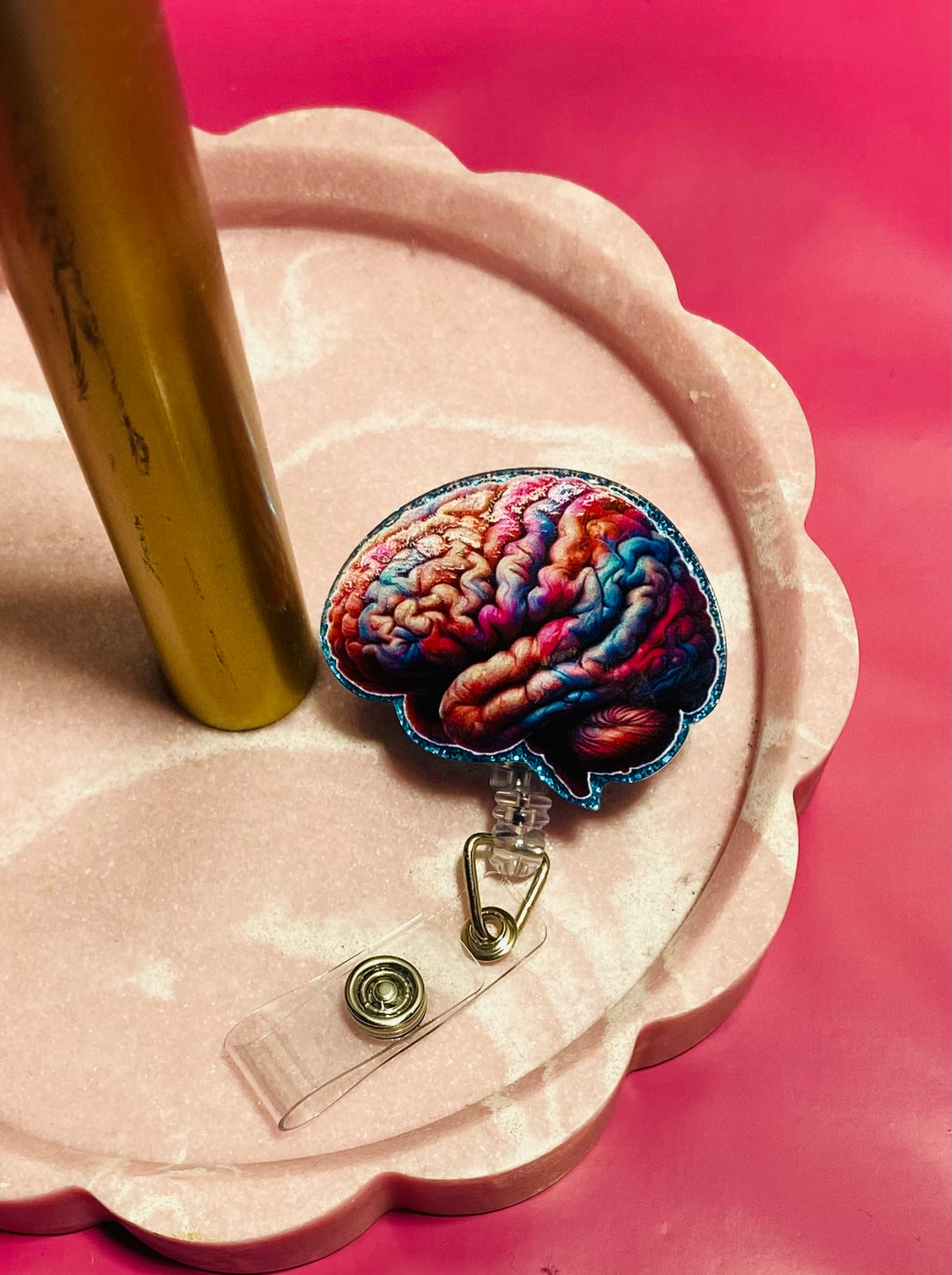 Colorful brain design badge holder on a pink stand with a pink background