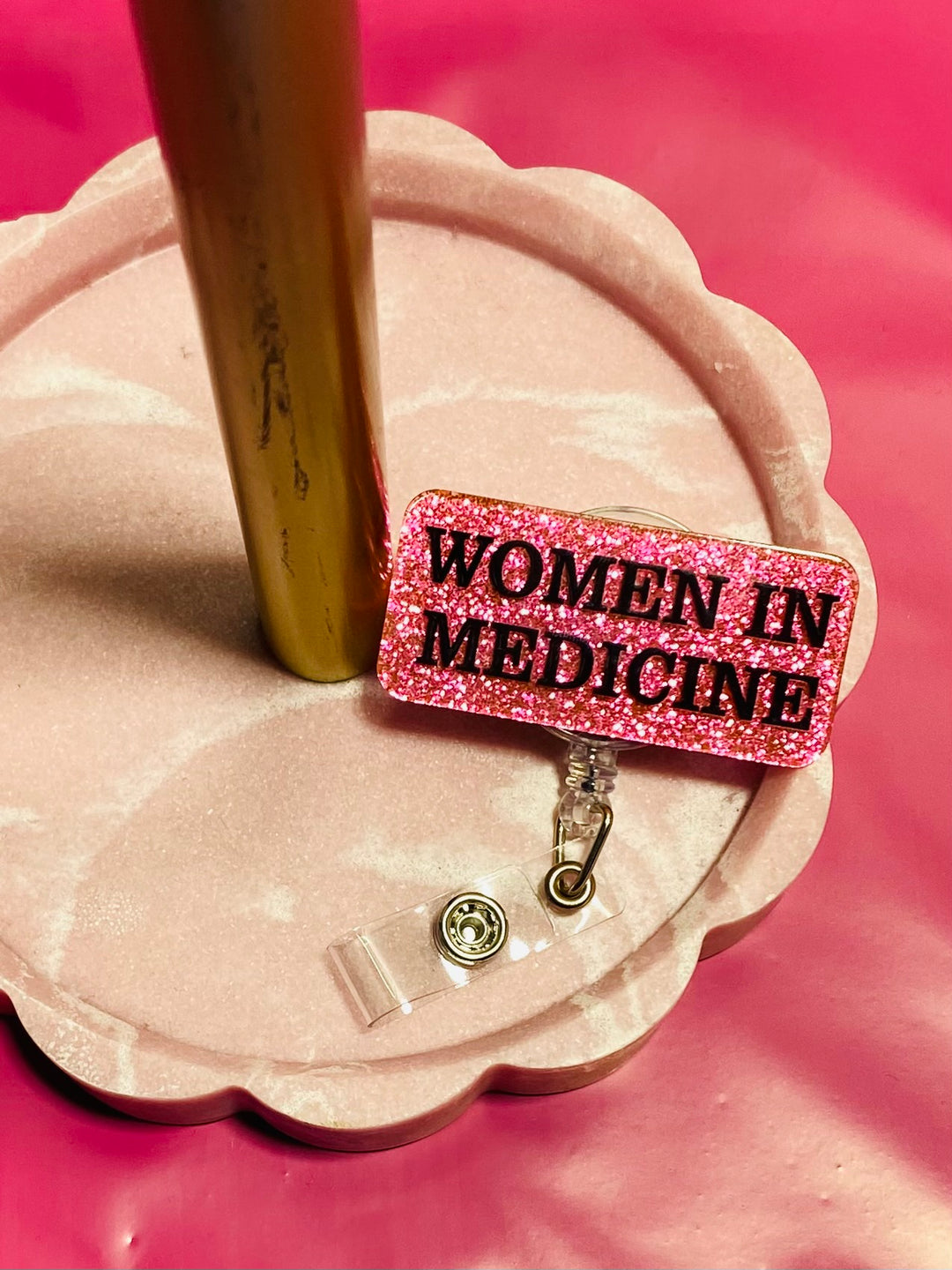 Pink badge reel with 'Women in Medicine' text on a pink glitter background