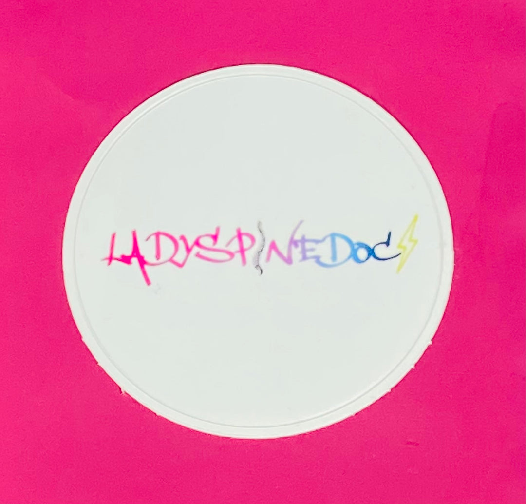 Circular white sticker with colorful Ladyspinedoc text on a pink background