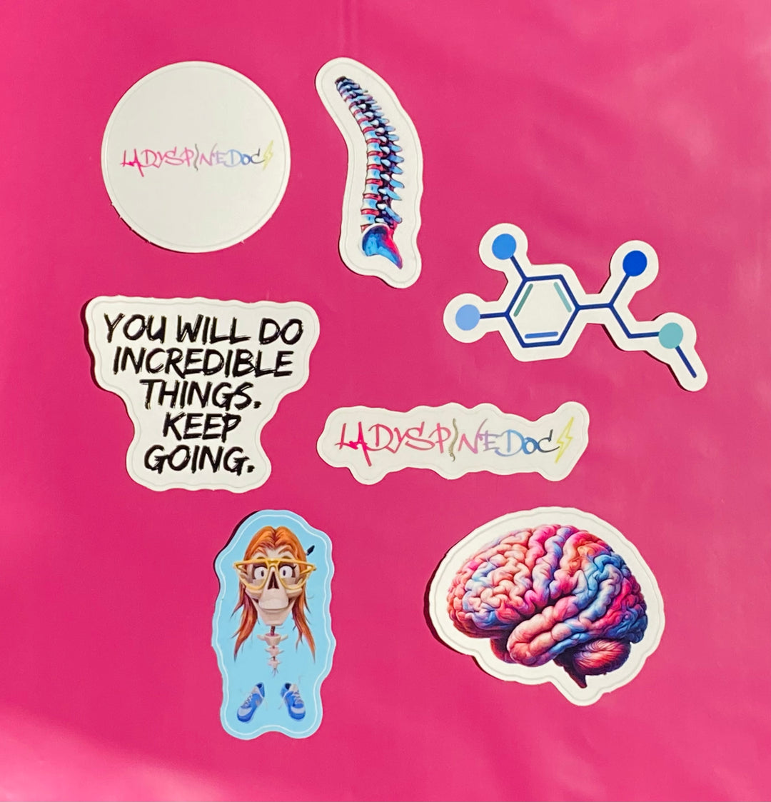 Collection of colorful Ladyspinedoc stickers on a pink background