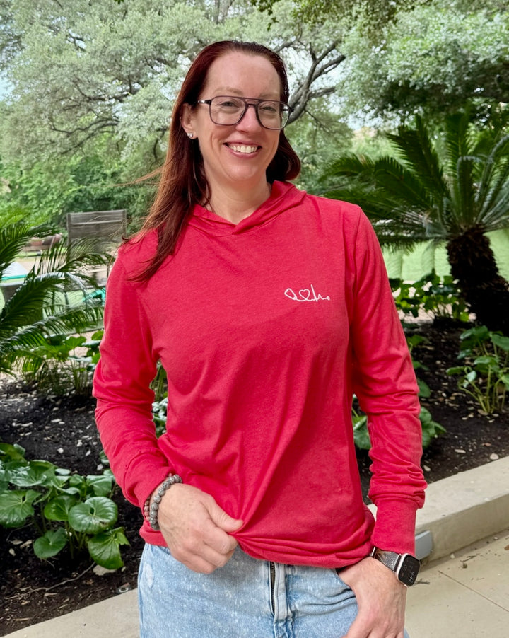 Smiling Dr. Betsy Grunch (Ladyspinedoc) wearing the Heart of Medicine Long Sleeve Tee Shirt – Lightweight, Red Hoodie