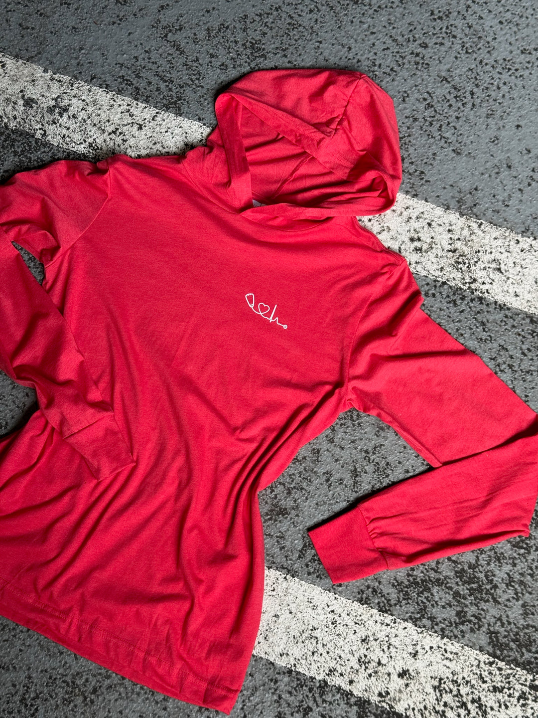Flat lay of red long sleeve Heart of Medicine hooded t-shirt by Ladyspinedoc 