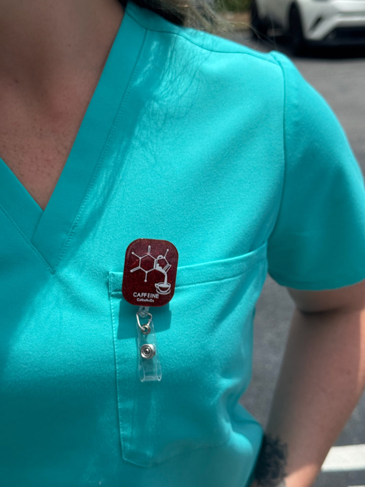 Ladyspinedoc Sparkly Red Enerjava Badge Reel clipped to front pocket of aqua scrubs