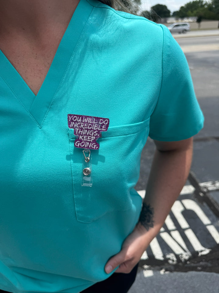 Person wearing Purple Glitter Incredible Badge Reel on front pocket of scrubs