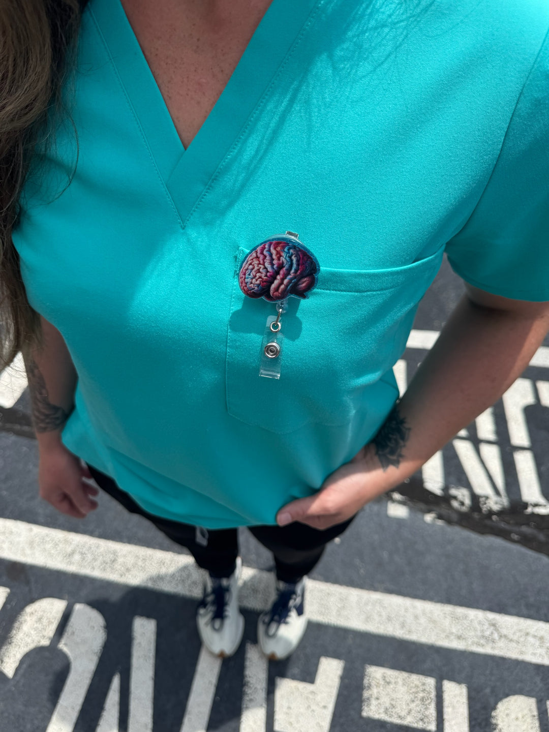 Colorful Brain Badge Reel - Retractable with Alligator Clip and Colorful Skull Design clipped to front pocket of scrubs