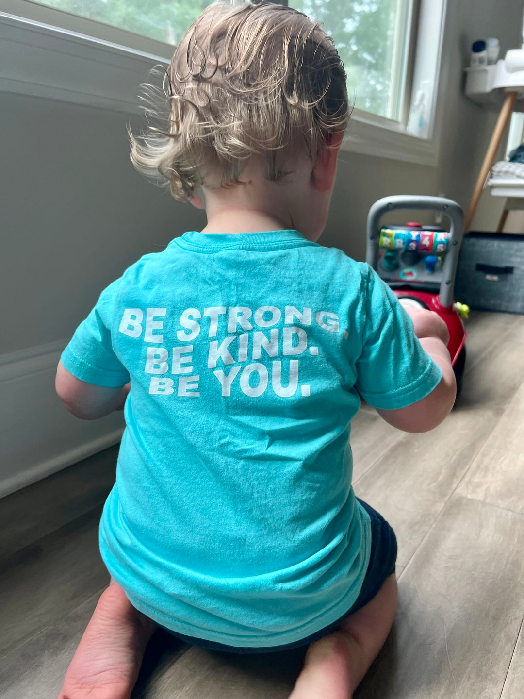 Back of toddler wearing the Be You Toddler Tee - Kids Caribbean Blue T-Shirt with Motivational “BE STRONG. BE KIND. BE YOU.” Motto shown on the back